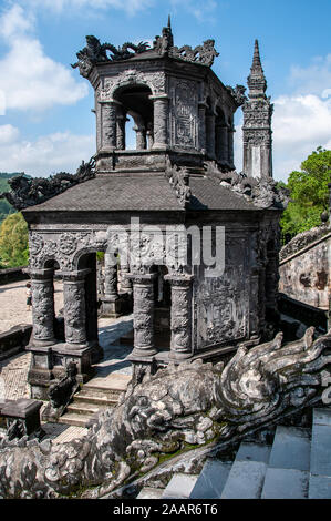 Des pavillons en pierre gris finement incrustés mènent à la somptueuse tombe de l'empereur Khai Dinh, près de Hué, au Vietnam Banque D'Images