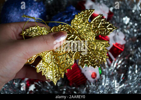 Gros plan de la main tenant la décoration de Noël feuille d'érable, photo-illustration Banque D'Images