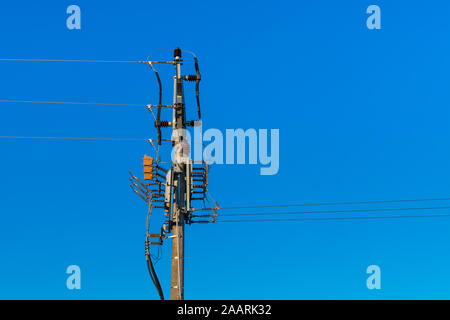 Sectionneurs moyenne tension sur l'électricité pylône. Pôle de la ligne d'alimentation avec des câbles et commutateurs d'isolateur sur fond de ciel bleu. Pour la sécurité publique ou la réparation Banque D'Images