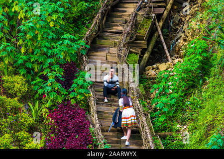 Cat Cat, le Vietnam - 10 octobre 2019 : un couple de prendre des photos sur l'escalier à côté de la rivière, dans le petit village de montagne de Cat Cat Banque D'Images