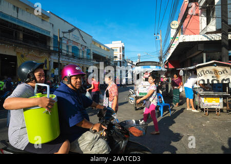 Une scène de rue à la principale zone de marché de la ville de Phuket, Phuket Thailand, un couple thaïlandais sur une moto dehors pour le shopping Banque D'Images