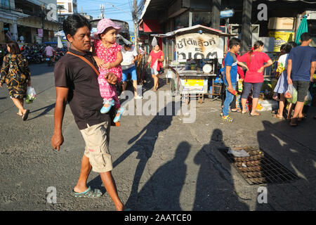 Un homme travailleur migrant du Myanmar (Birmanie) avec son enfant, pour le magasinage le dimanche sur le marché principal de la ville de Phuket, Phuket, Thaïlande Banque D'Images