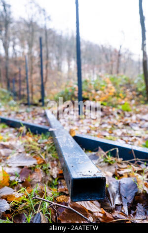 Flensburg, Allemagne. 22 Nov, 2019. Les poteaux de clôture sont allongés sur le sol de la forêt. Dans quelques jours, la controverse des sangliers clôture à la frontière germano-danoise aurait dû être terminé. Les danois sont la construction de la clôture de la mer du Nord à la mer Baltique ; c'est d'être un 70 km de long et 1,50 mètres de haut rempart pour protéger les élevages de porcs de peste porcine africaine (ASP). (Pour 'dpa qui ne rentre pas du tout' - Danemark's wild boar clôture presque terminée) Crédit : Frank Molter/dpa/Alamy Live News Banque D'Images