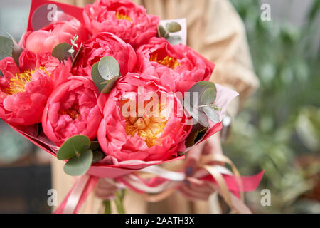 Bouquet de pivoines, Mono Coral Charm, dans les mains de womans. Boutique de fleurs modernes. Travail fini de la fleuriste. Frais de livraison de fleurs à partir de la boutique en ligne Banque D'Images