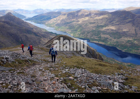 Trois hommes marchant sur Sgoilte Stob Coire à partir de la montagne écossaise 'Corbett Garbh Bheinn' au-dessus le Loch Leven, Highlands, Ecosse, Royaume-Uni. Banque D'Images