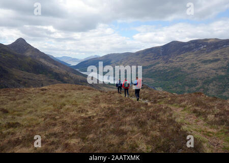 Trois hommes marchant sur Sgoilte Stob Coire à partir de la montagne écossaise 'Corbett Garbh Bheinn' au-dessus le Loch Leven, Highlands, Ecosse, Royaume-Uni. Banque D'Images