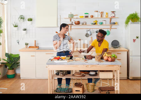 Couple multiethnique déjeunant ensemble dans la cuisine Banque D'Images