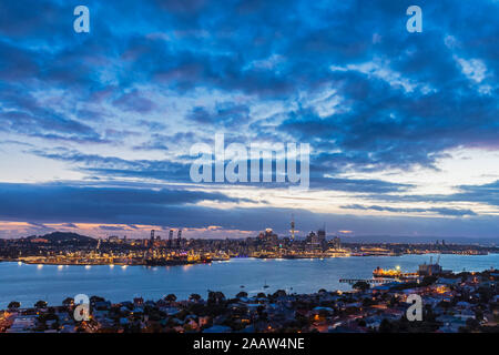 Les bâtiments modernes par mer contre ciel nuageux au crépuscule dans Auckland, Nouvelle-Zélande Banque D'Images