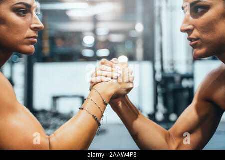 Jumelles en bonne forme faisant Arm wrestling challenge dans une salle de sport Banque D'Images
