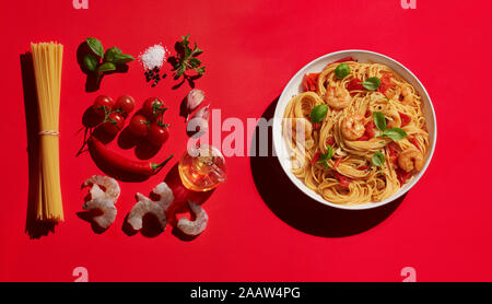 Bol de pâtes aux crevettes acheter divers ingrédients sur fond rouge Banque D'Images