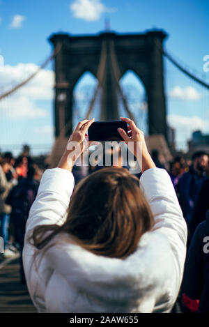 Femme de prendre une photo du pont de Brooklyn, New York, United States Banque D'Images