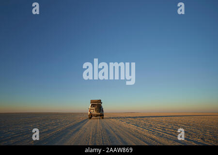 Véhicule hors route contre le ciel clair, Makgadikgadi Pans, Botswana Banque D'Images