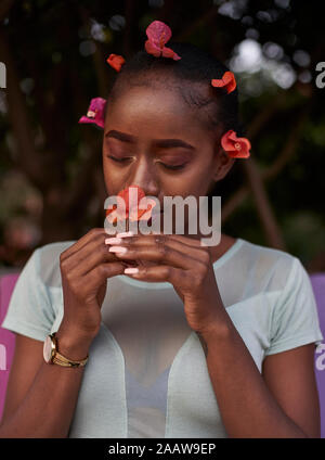 Portrait of young woman smelling a flower Banque D'Images