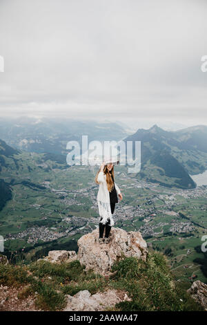 Young woman wearing hat, debout sur viewpoint, Grosser Mythen, Suisse Banque D'Images