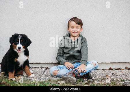 Garçon jouant avec son chien de Montagne bernois dans le jardin Banque D'Images