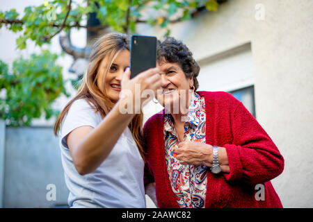 Femme et senior woman taking un smartphone avec selfies Banque D'Images