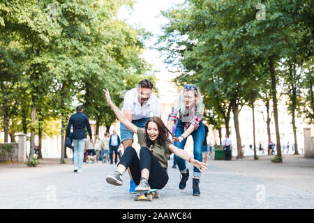 Groupe de trois amis s'amusant avec skateboard Banque D'Images