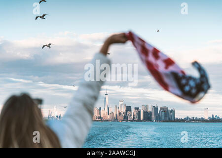 Vue arrière de la femme avec le drapeau des États-Unis à New York, USA Banque D'Images