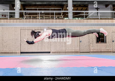 Femme exerçant en salle de sport de l'air mi-flottant Banque D'Images