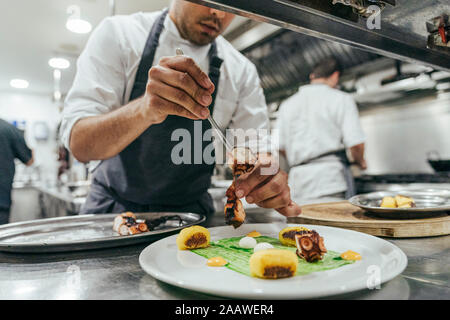 Chef de garnir la plaque avec la nourriture Banque D'Images