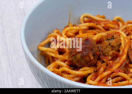Spaghetti aux Boulettes de viande à la tomate suce avec herbes et épices dans un bol vert. Sur une surface en bois gris Banque D'Images