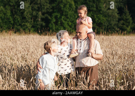 Portrait de famille des grands-parents avec leurs petits-enfants dans un champ d'avoine Banque D'Images