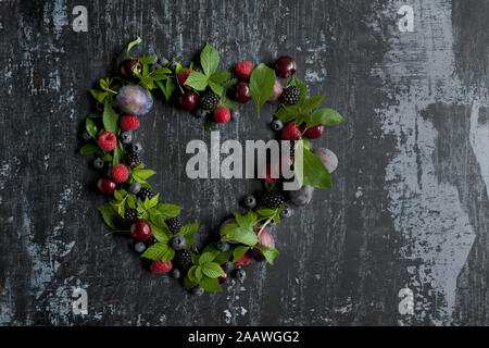 Tourné directement au-dessus de divers fruits avec des feuilles disposées en forme de coeur sur table Banque D'Images