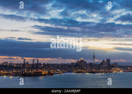 Les bâtiments modernes par mer contre ciel nuageux au crépuscule dans Auckland, Nouvelle-Zélande Banque D'Images