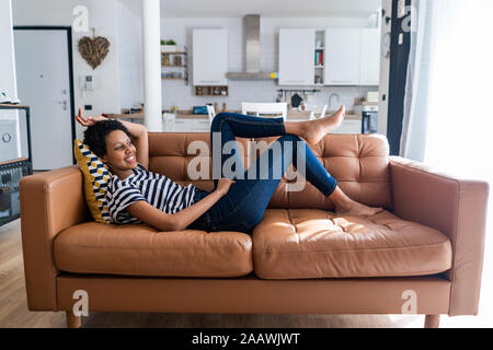 Young woman lying on détendue à la maison de la table Banque D'Images