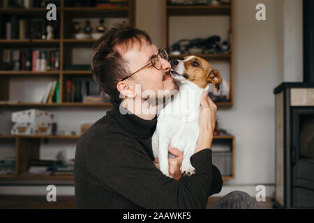 Jeune homme avec Jack Russel terrier, léchant Banque D'Images