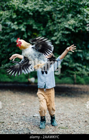 Garçon publie sur une ferme biologique de poulet Banque D'Images