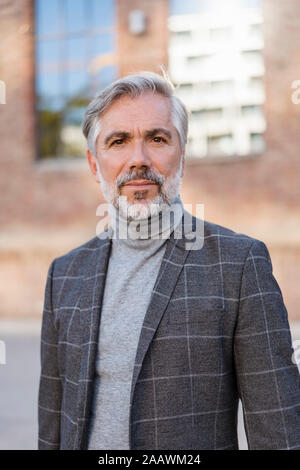 Portrait of mature businessman à la mode à un bâtiment en brique Banque D'Images