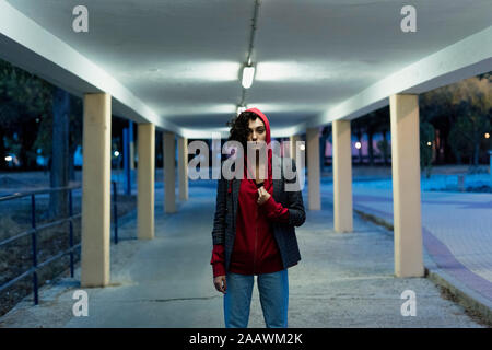 Portrait of young woman wearing red Hooded Jacket dans la soirée Banque D'Images