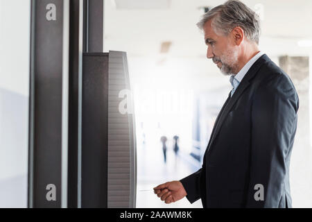 Businessman le retrait d'argent à un guichet automatique Banque D'Images