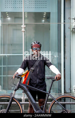 Portrait de jeune homme élégant avec location et messenger sac dans la ville Banque D'Images