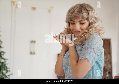 Cerf en bois dans les mains d'une jeune blonde. Femme heureuse de se préparer pour le nouvel an Banque D'Images