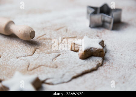 Cookies stars coupé de la préparation de la pâte avant cuisson avec des biscuits préparés, rouleau à pâtisserie et la faucheuse. Banque D'Images