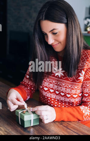 Woman decorating Christmas present Banque D'Images
