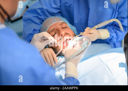 Médecin Dentiste effectuant un implant patient Banque D'Images