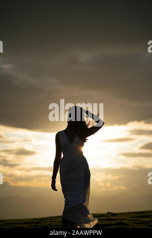 Young woman wearing white dress au coucher du soleil Banque D'Images