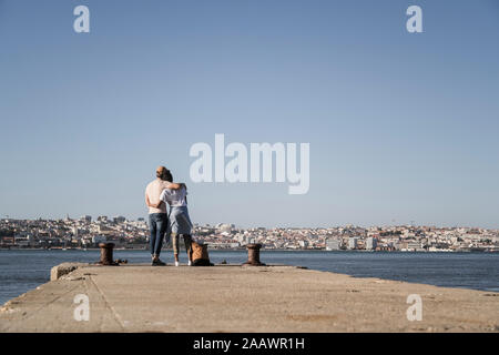 Jeune couple debout sur une jetée à la mer, Lisbonne, Portugal Banque D'Images