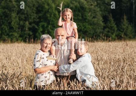 Portrait de famille des grands-parents avec leurs petits-enfants dans un champ d'avoine Banque D'Images