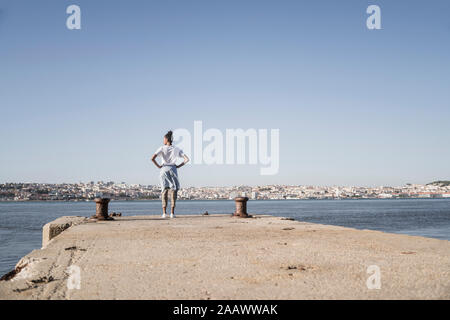 Jeune femme debout sur une jetée à la mer, Lisbonne, Portugal Banque D'Images