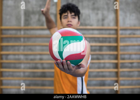 Homme tenant un ballon de volley-ball prêt à lancer un jeu pendant un match de volley Banque D'Images