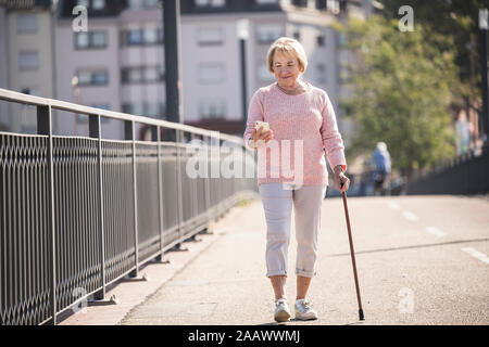 Hauts femme marche sur la passerelle, à l'aide de bâton de marche Banque D'Images