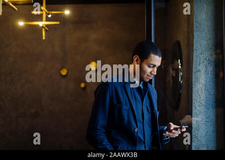 Jeune homme de bureau élégant, using smartphone Banque D'Images