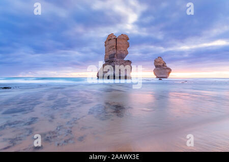 Les roches de la pile en mer à Gibson Mesures contre ciel nuageux pendant le coucher du soleil, Victoria, Australie Banque D'Images