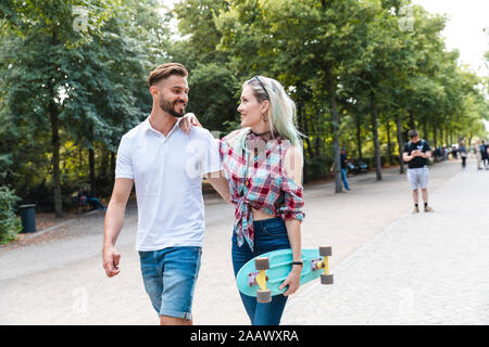 Happy young couple walking in a park Banque D'Images