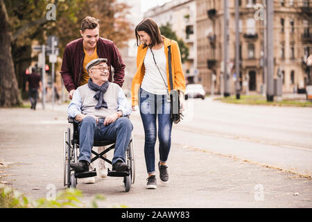 Happy senior man in wheelchair passer du temps avec ses petits-enfants Banque D'Images