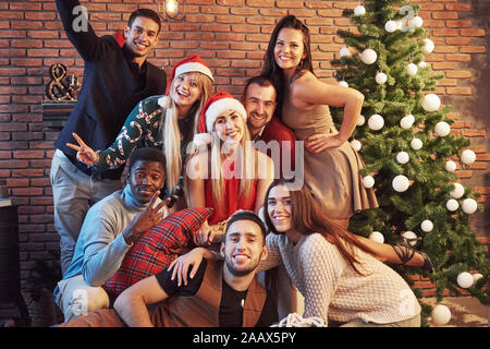 Groupe d'сheerful de vieux amis à communiquer les uns avec les autres. Nouvelle année s'en vient. Célébrer la nouvelle année dans une atmosphère cosy home Banque D'Images